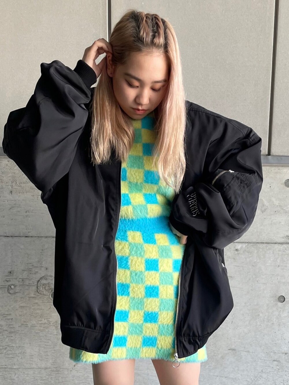 ブラック系のMA-1、ブルー系のニット/セーター、ブルー系のスカートを着用したレディースの冬コーディネートの2枚目の写真