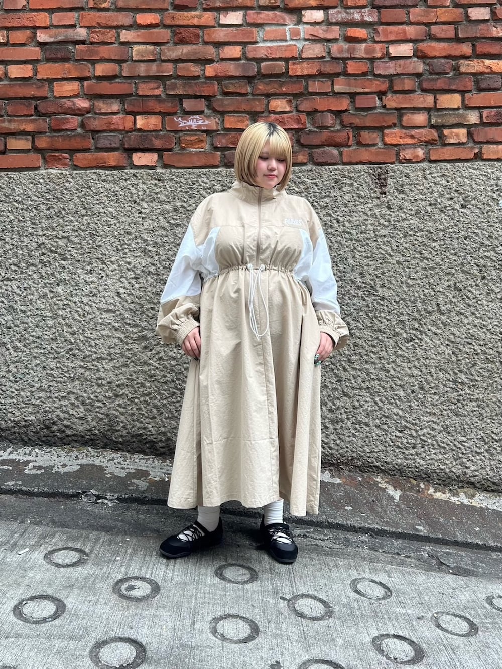 ベージュ系のワンピースを着用したレディースの春コーディネートの2枚目の写真