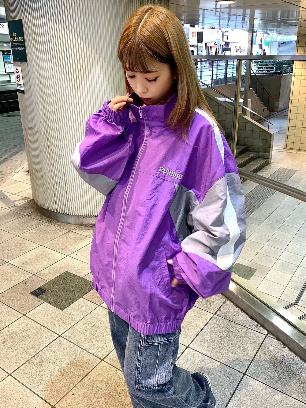 ホワイト系のTシャツ/カットソー、パープル系のナイロンジャケット、ブルー系のデニムパンツを着用したレディースの春コーディネートの2枚目の写真