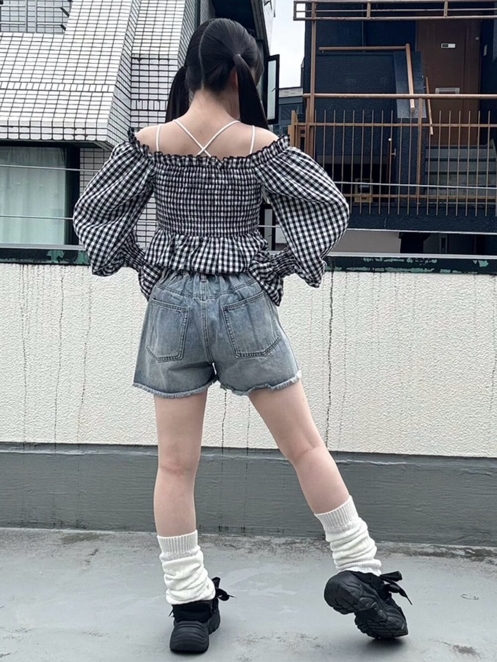 ブラック系のシャツ/ブラウス、ブルー系のデニムパンツを着用したレディースの春コーディネートの4枚目の写真