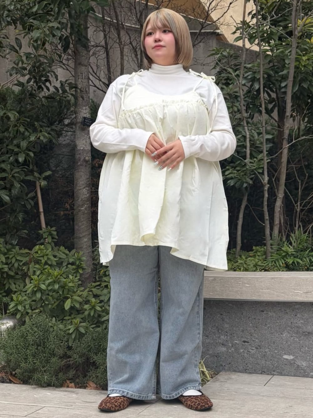 ホワイト系のワンピース、ホワイト系のTシャツ/カットソー、ブルー系のデニムパンツを着用したレディースの冬コーディネートの2枚目の写真