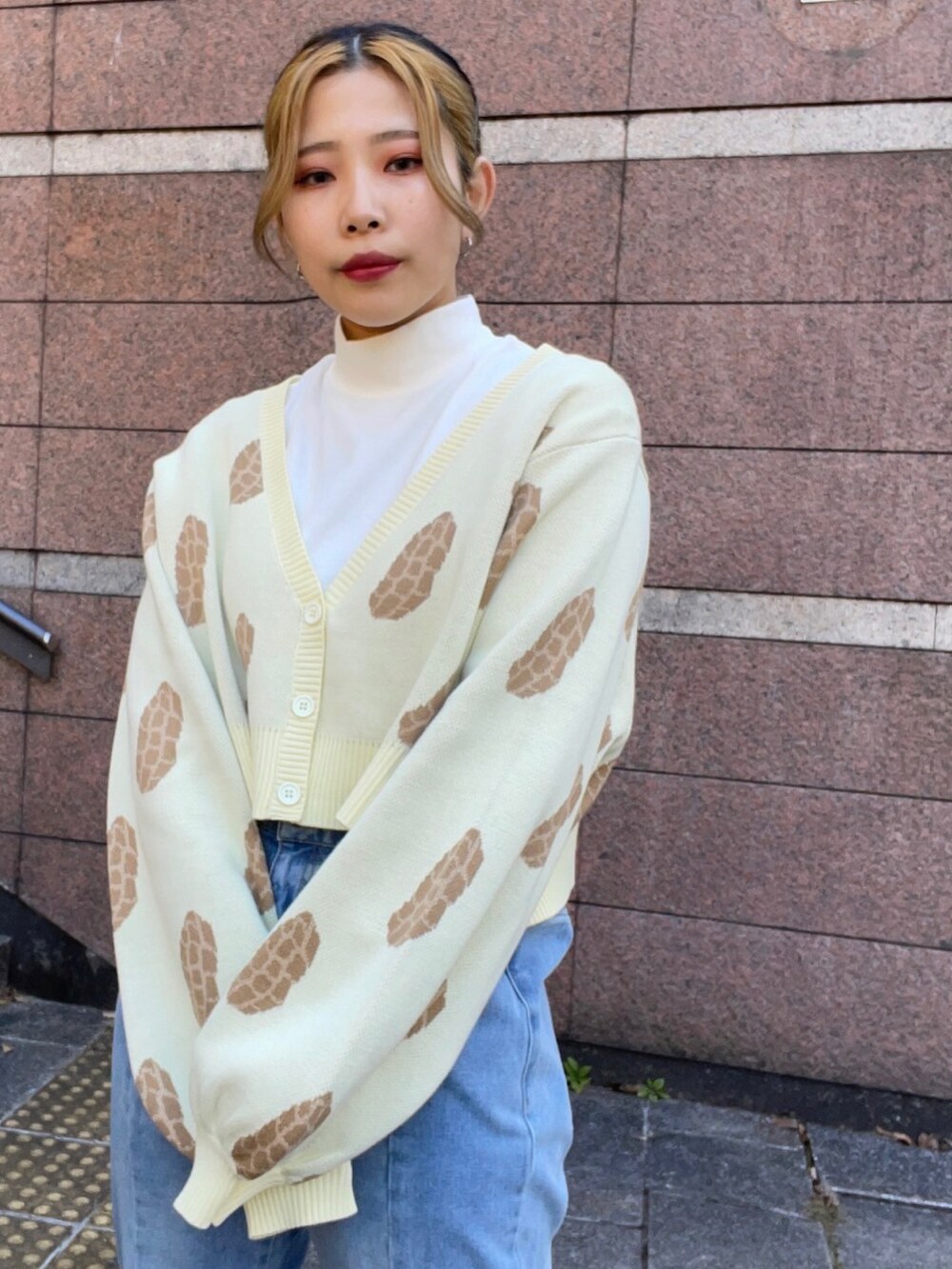 ブルー系のデニムパンツ、ベージュ系のカーディガン/ボレロ、ホワイト系のTシャツ/カットソーを着用したレディースの冬コーディネートの2枚目の写真