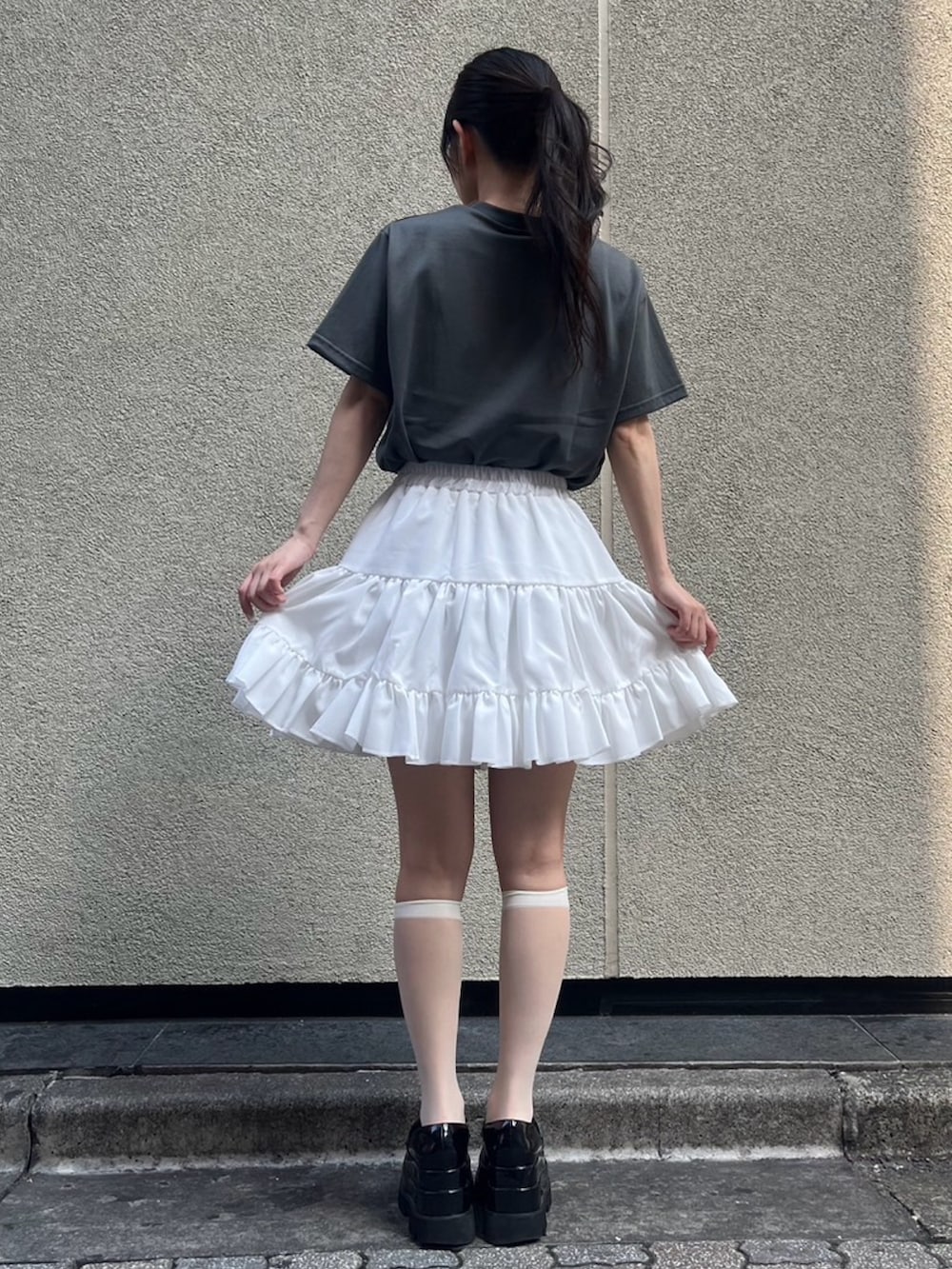 ホワイト系のスカート、ブラック系のTシャツ/カットソーを着用したレディースの夏コーディネートの3枚目の写真