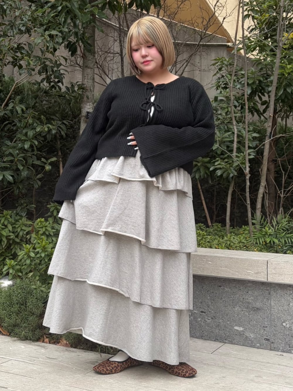 グレー系のスカート、ブラック系のカーディガン/ボレロを着用したレディースの冬コーディネートの2枚目の写真