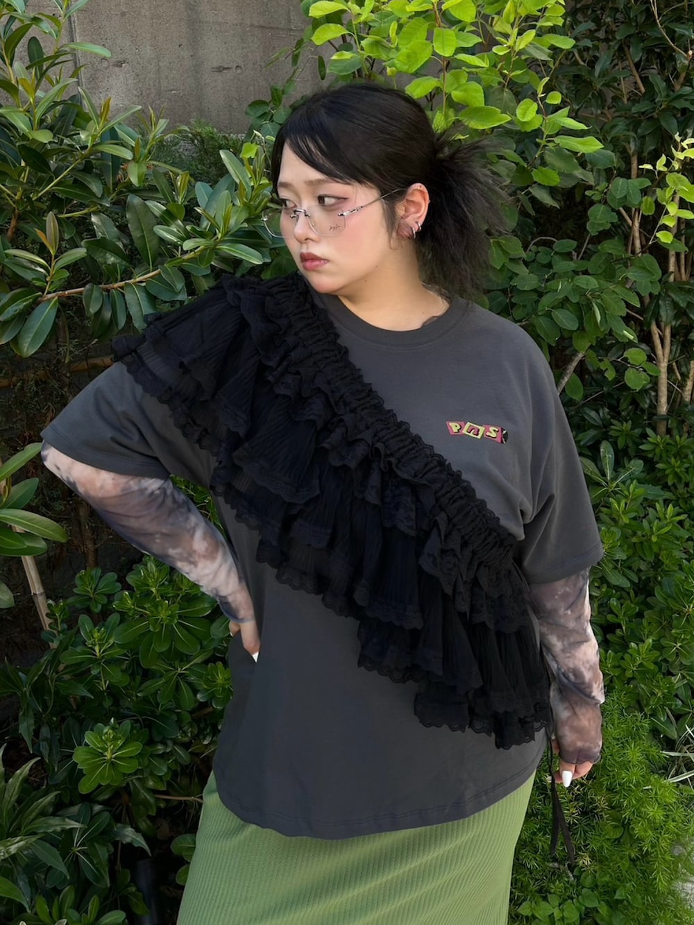 グリーン系のスカート、グレー系のTシャツ/カットソー、ブラック系のスカートを着用したレディースの秋コーディネートの5枚目の写真