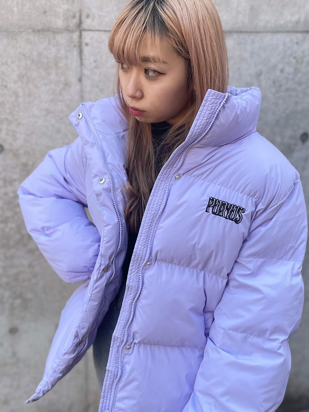 ブルー系のデニムパンツ、パープル系のダウンジャケット/コート、ブラック系のTシャツ/カットソーを着用したレディースの冬コーディネートの3枚目の写真