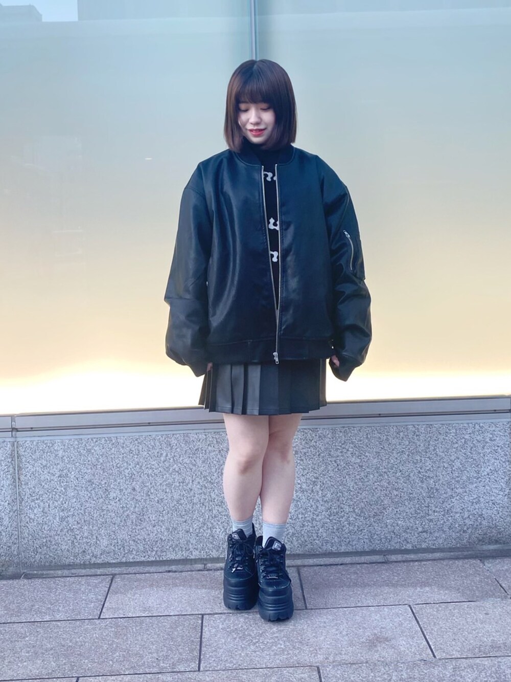 ブラック系のニット/セーター、ブラック系のMA-1、ブラック系のスカートを着用したレディースの冬コーディネートの2枚目の写真