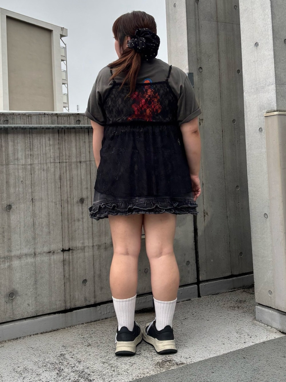 ブラック系のチュニック、ブラック系のデニムスカート、ブラック系のTシャツ/カットソーを着用したレディースの夏コーディネートの5枚目の写真