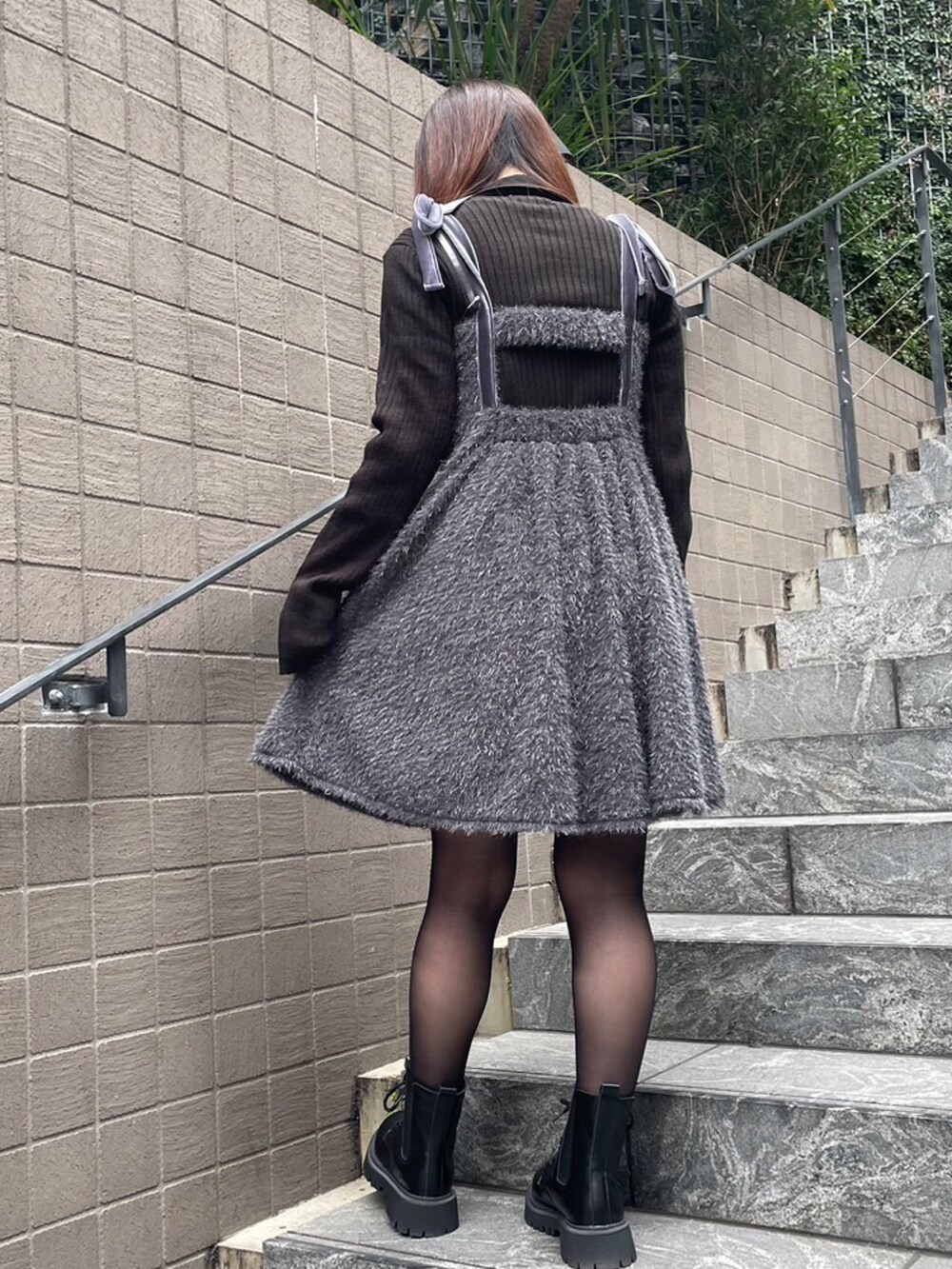 グレー系のワンピース、ブラック系のニット/セーターを着用したレディースの冬コーディネートの2枚目の写真