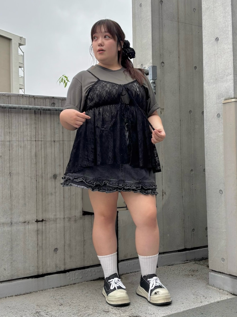 ブラック系のチュニック、ブラック系のデニムスカート、ブラック系のTシャツ/カットソーを着用したレディースの夏コーディネートの3枚目の写真