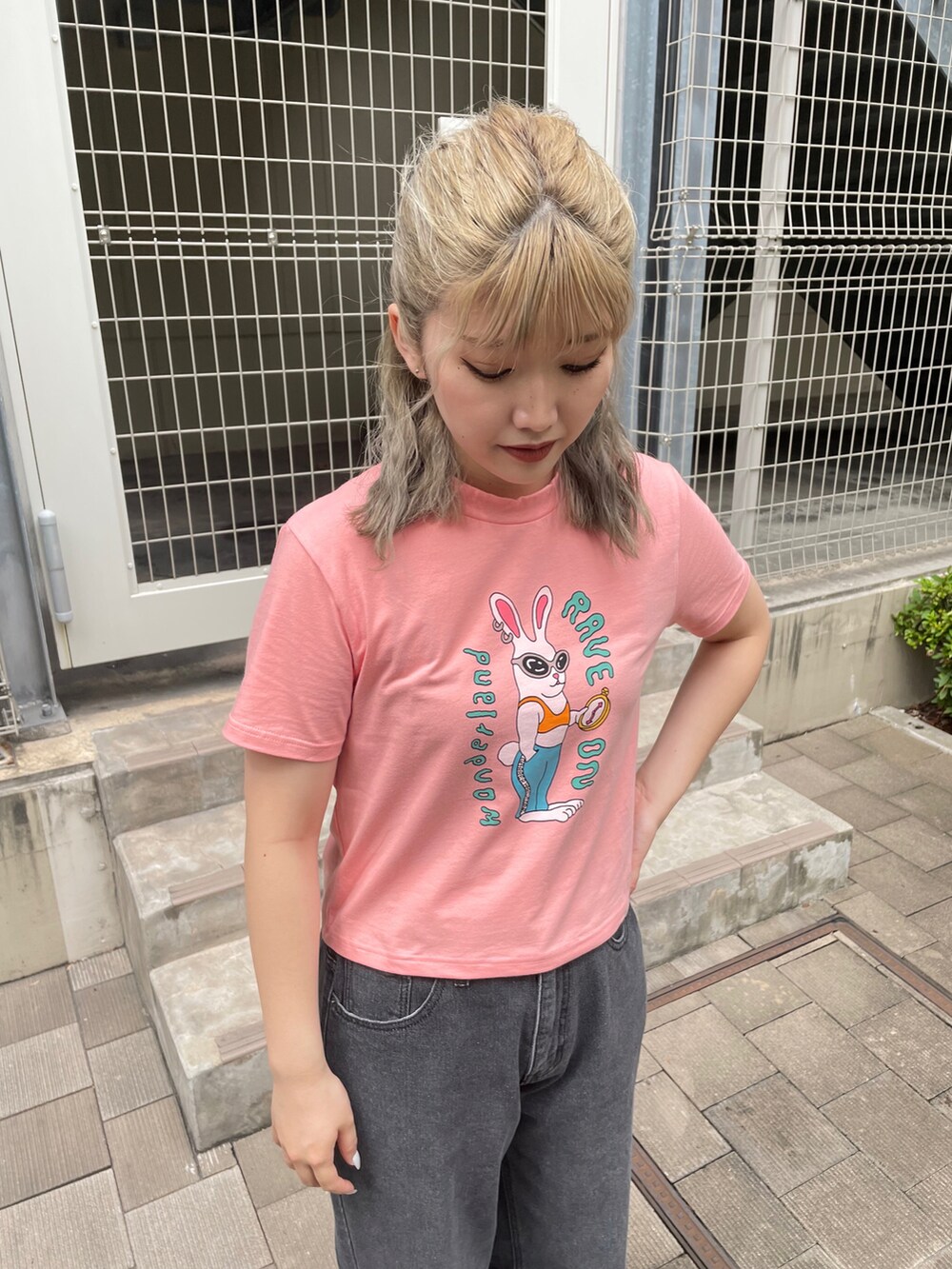 ブラック系のデニムパンツ、オレンジ系のTシャツ/カットソーを着用したレディースの夏コーディネートの2枚目の写真