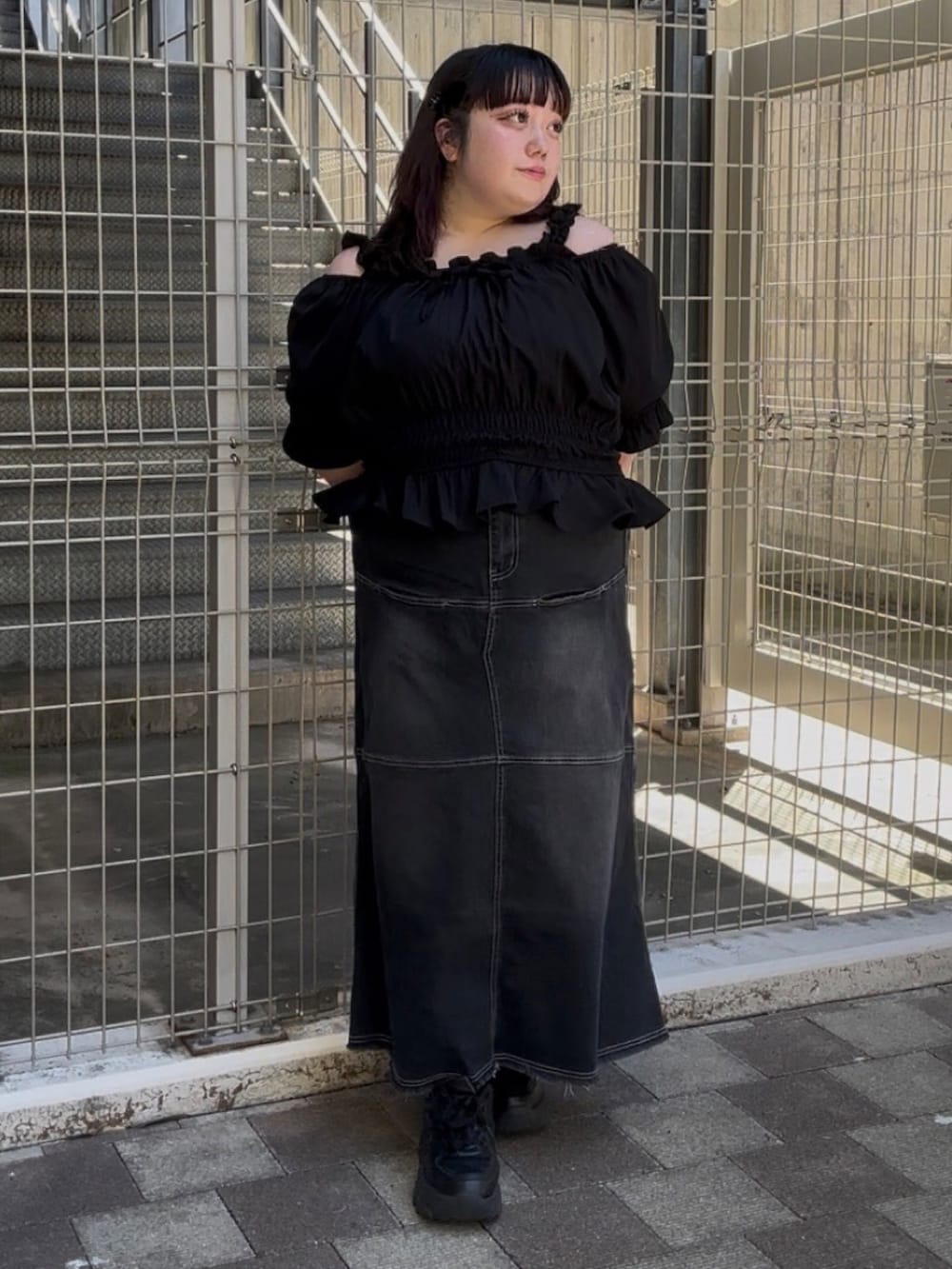 ブラック系のデニムスカート、ブラック系のシャツ/ブラウスを着用したレディースの夏コーディネートの2枚目の写真