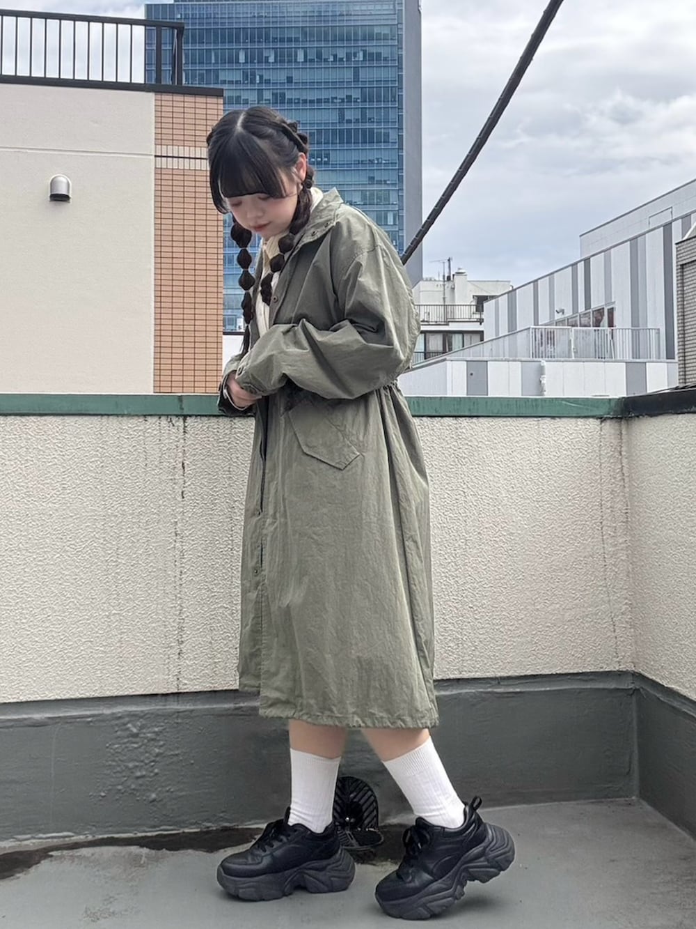 イエロー系のシャツ/ブラウス、グリーン系のモッズコート、ブルー系のデニムスカートを着用したレディースの春コーディネートの3枚目の写真