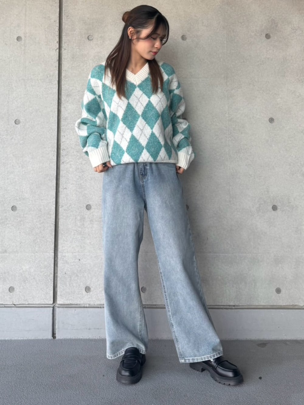 ブルー系のデニムパンツ、グリーン系のニット/セーターを着用したレディースの冬コーディネートの2枚目の写真