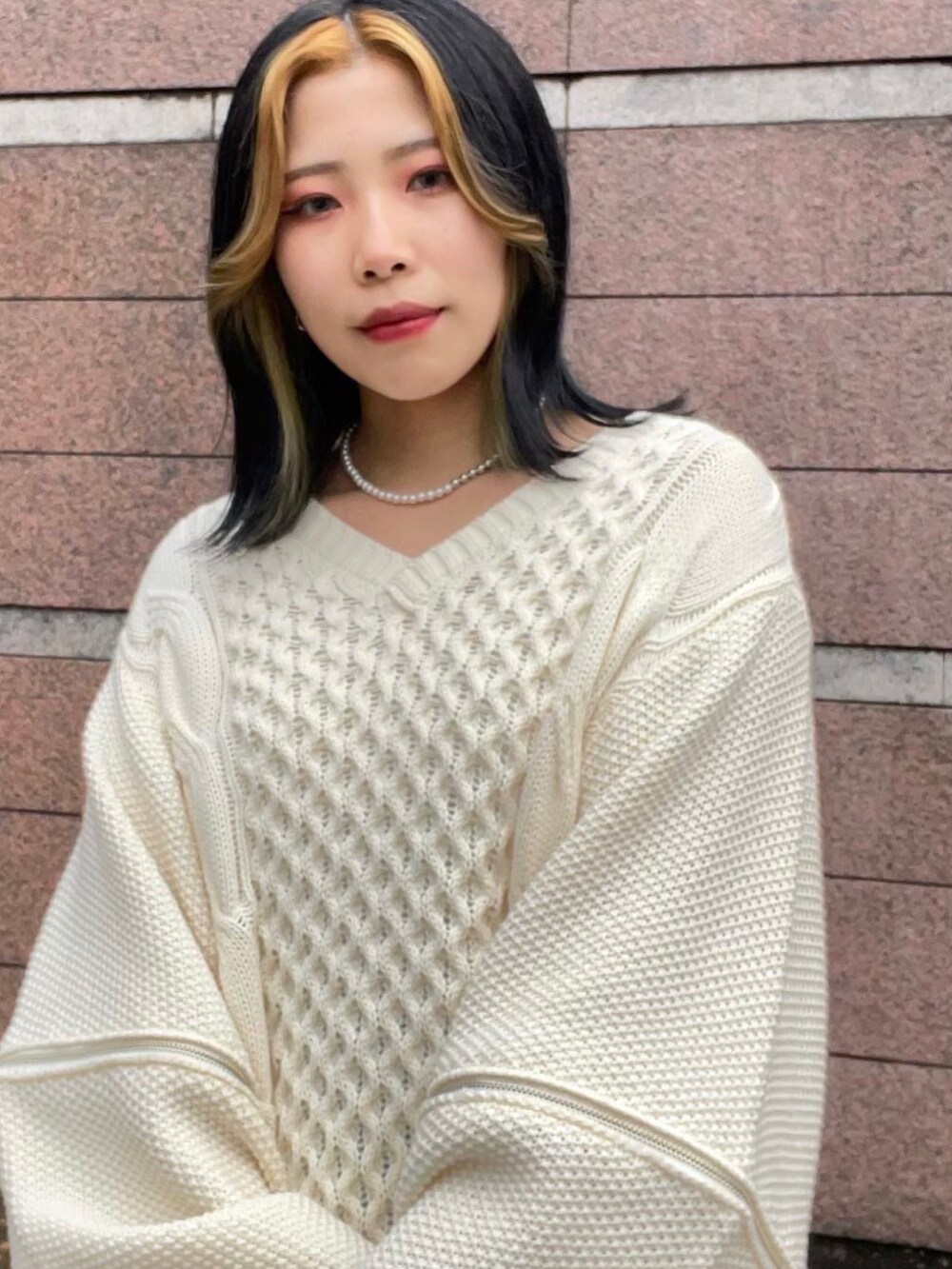 ホワイト系のニット/セーター、ブラック系のその他パンツを着用したレディースの冬コーディネートの2枚目の写真