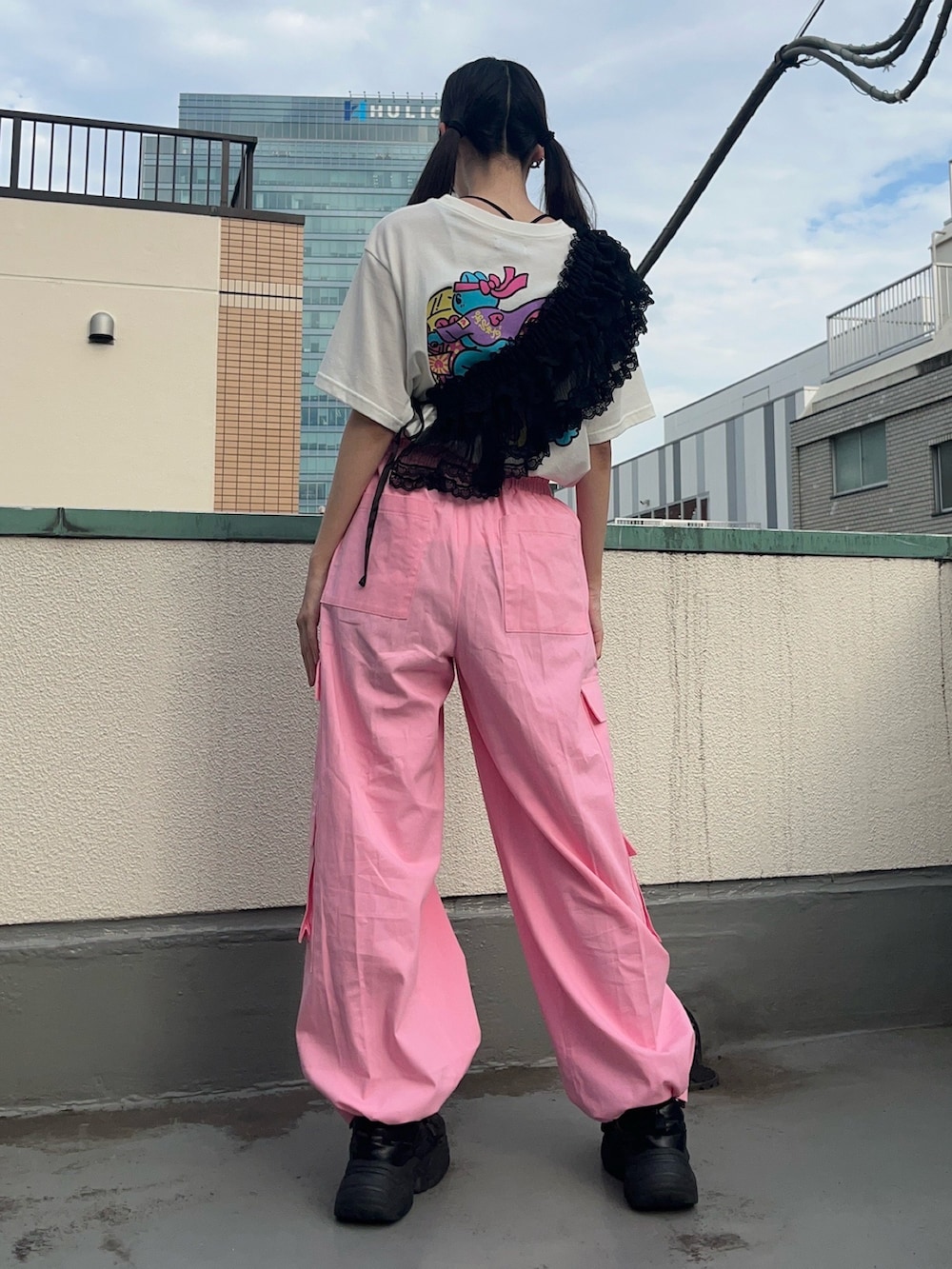 ピンク系のカーゴパンツ、ブラック系のスカート、ホワイト系のTシャツ/カットソーを着用したレディースの秋コーディネートの4枚目の写真