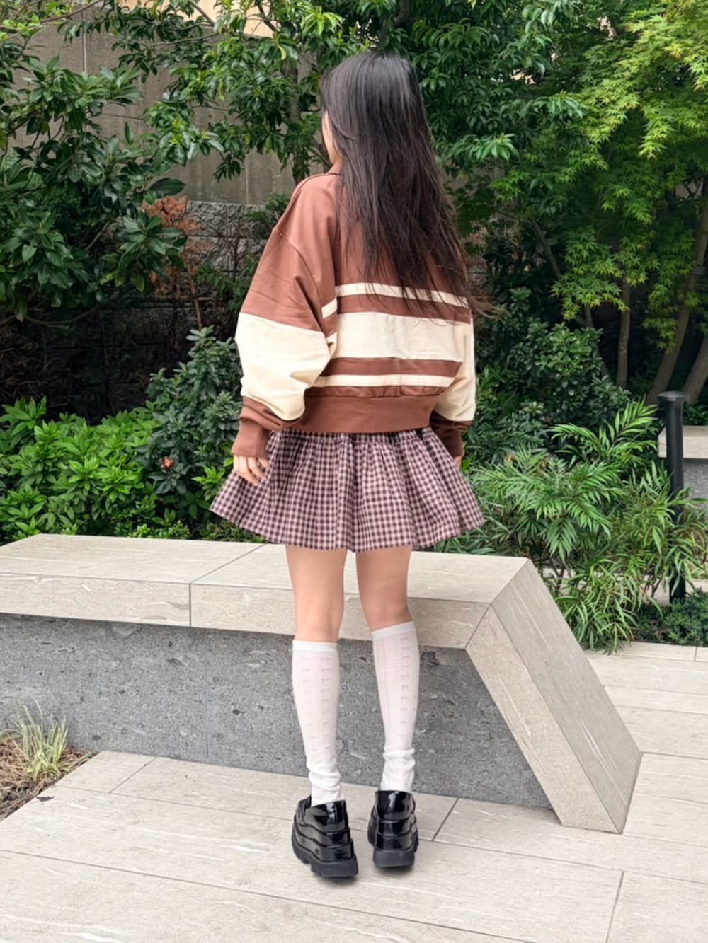 ブラウン系のスカート、ブラウン系のスウェットを着用したレディースの春コーディネートの3枚目の写真