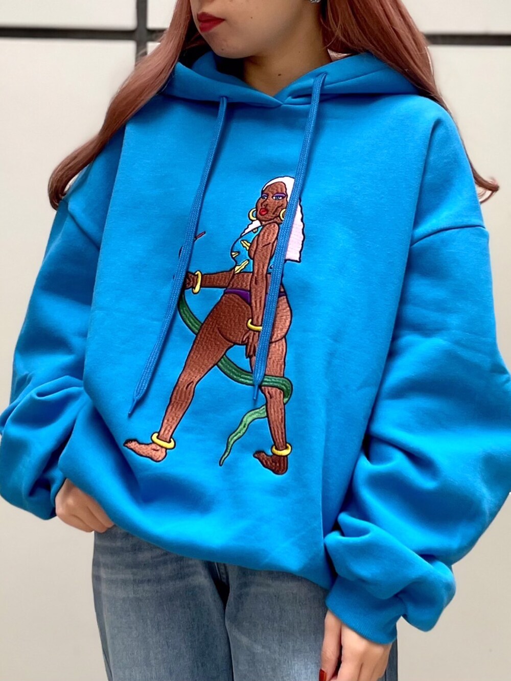 ブルー系のパーカー、ブルー系のデニムパンツを着用したレディースの冬コーディネートの2枚目の写真