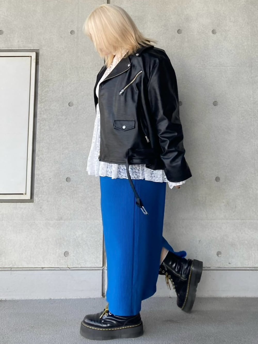 ブラック系のライダースジャケット、ホワイト系のTシャツ/カットソー、ブルー系のスカートを着用したレディースの秋コーディネートの4枚目の写真