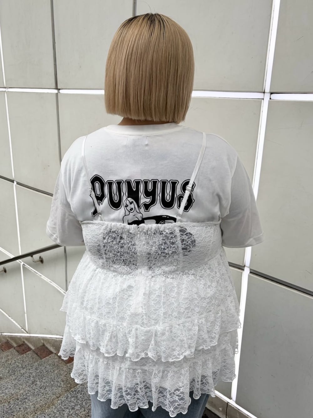 ブルー系のデニムパンツ、ホワイト系のワンピース、ブラック系のブルゾンを着用したレディースの春コーディネートの5枚目の写真