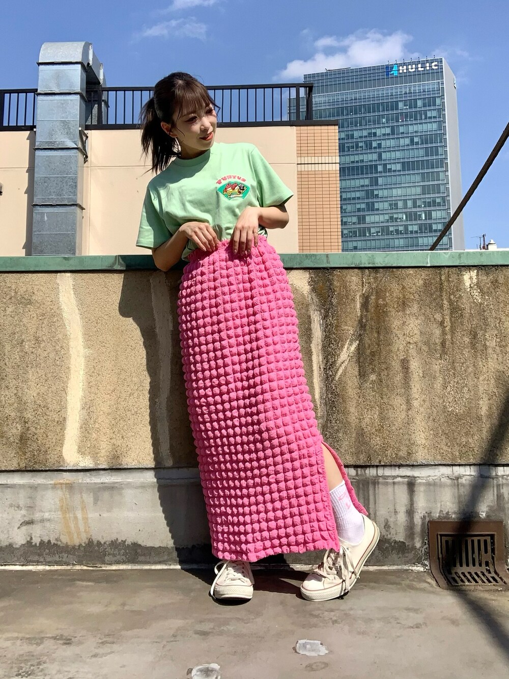 ピンク系のスカート、グリーン系のTシャツ/カットソーを着用したレディースの春コーディネートの2枚目の写真