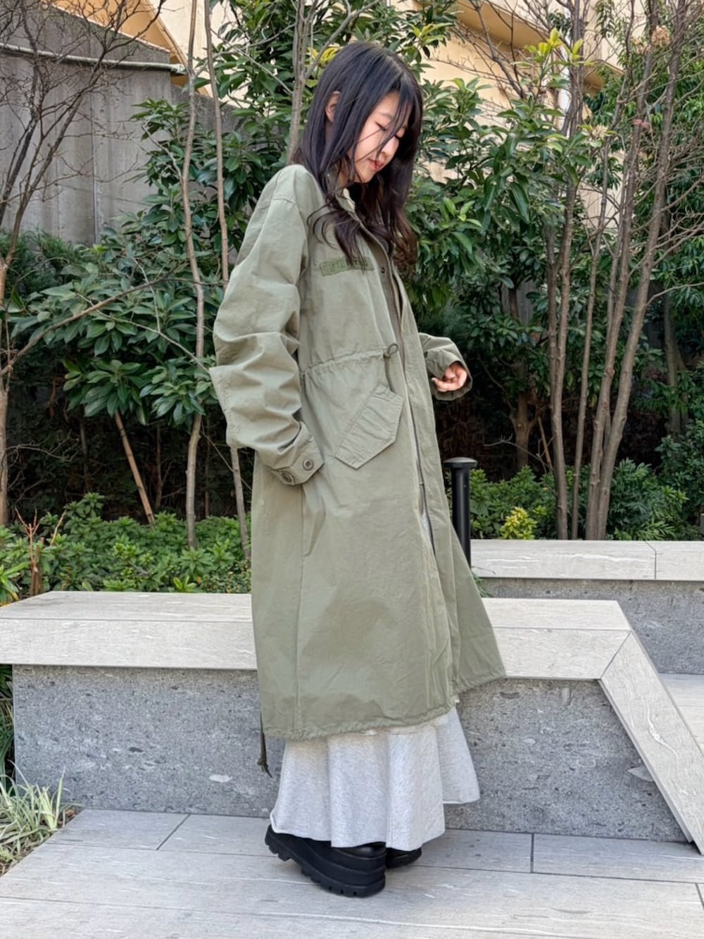 イエロー系のTシャツ/カットソー、グリーン系のモッズコート、グレー系のスカートを着用したレディースの冬コーディネートの3枚目の写真