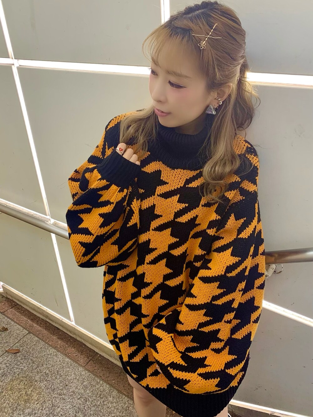 オレンジ系のニット/セーターを着用したレディースの冬コーディネートの2枚目の写真