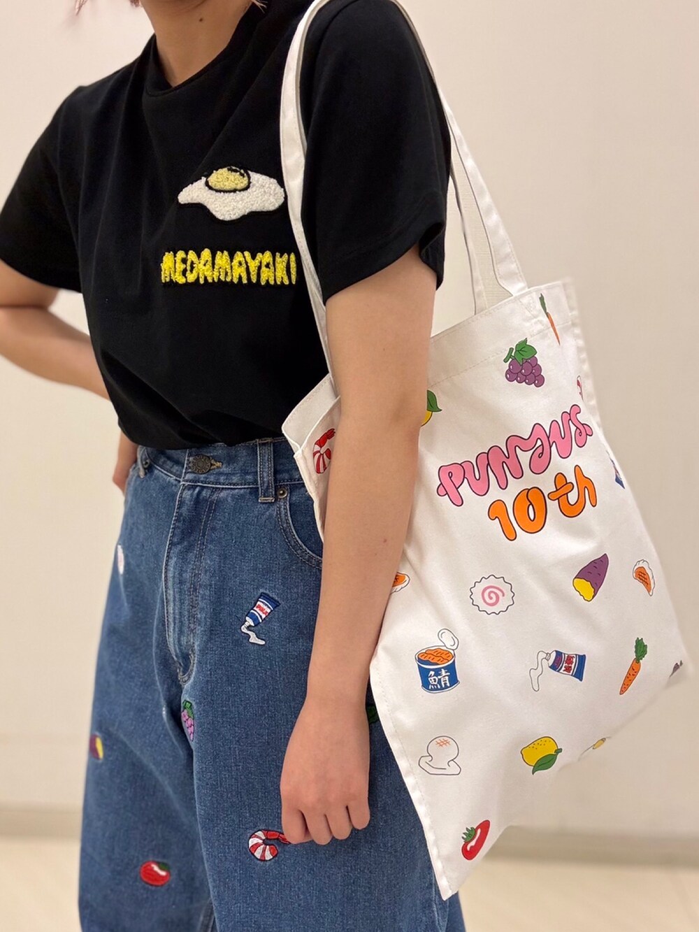 ブラック系のTシャツ/カットソー、ブルー系のデニムパンツ、ホワイト系のトートバッグを着用したレディースの夏コーディネートの3枚目の写真