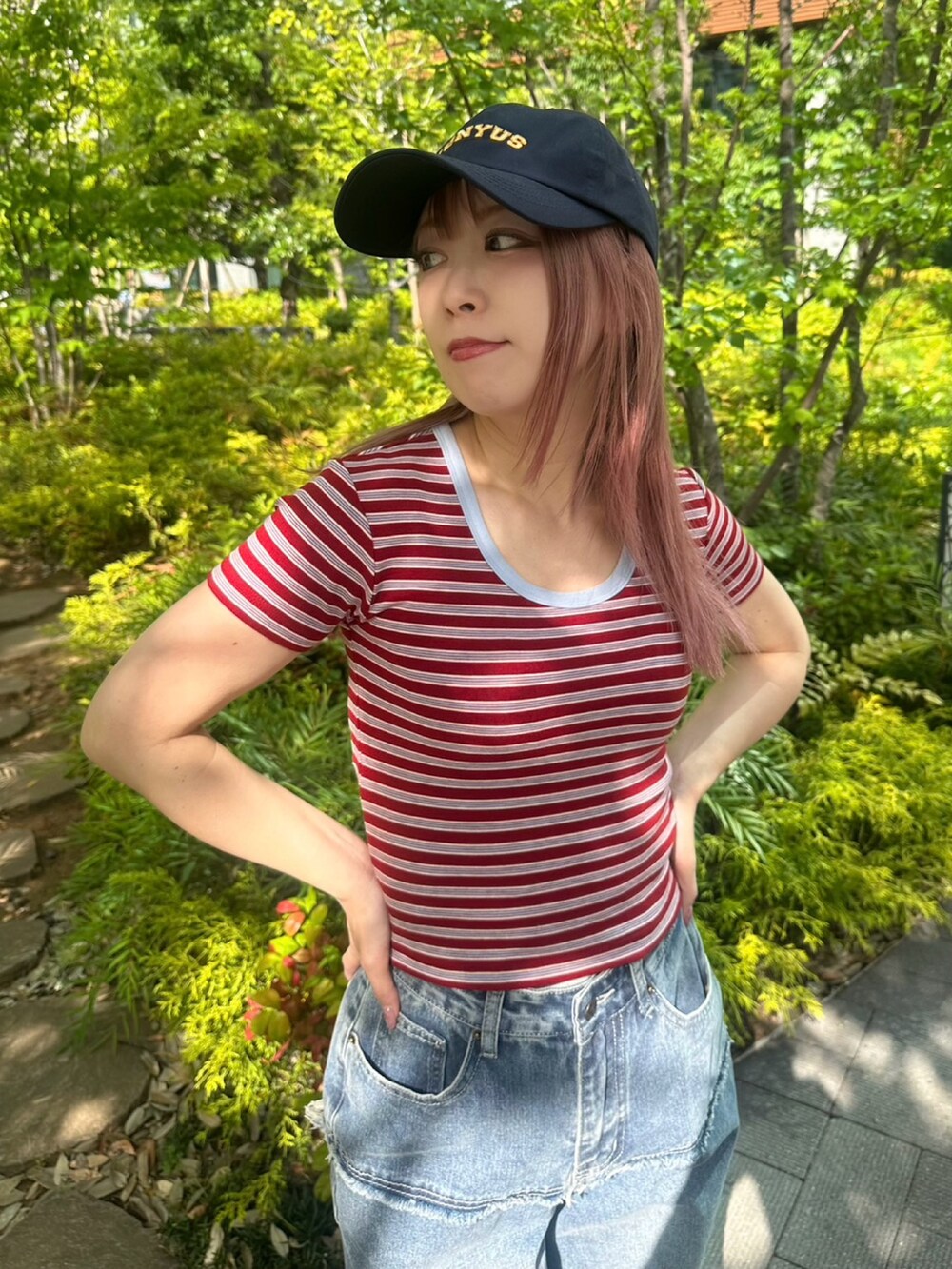 レッド系のTシャツ/カットソー、ブルー系のキャップを着用したレディースの春コーディネートの3枚目の写真