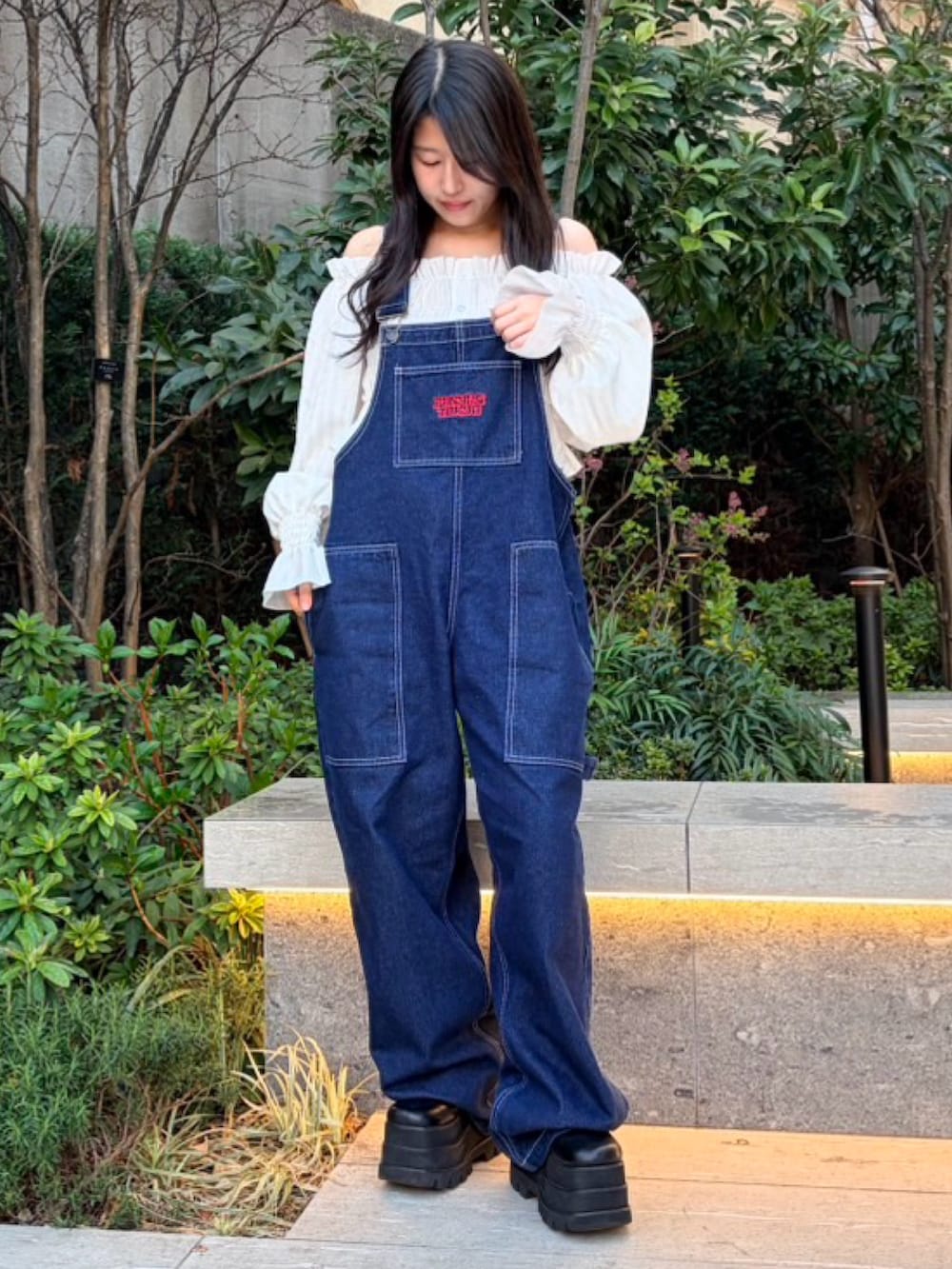 ブルー系のサロペット/オーバーオール、ホワイト系のシャツ/ブラウスを着用したレディースの春コーディネートの2枚目の写真