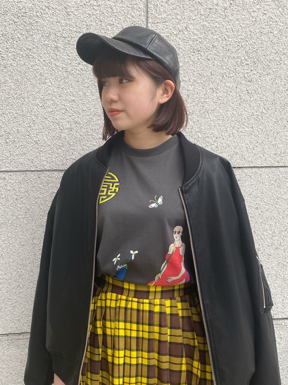 イエロー系のスカート、ブラック系のTシャツ/カットソー、ブラック系のMA-1を着用したレディースの冬コーディネートの3枚目の写真