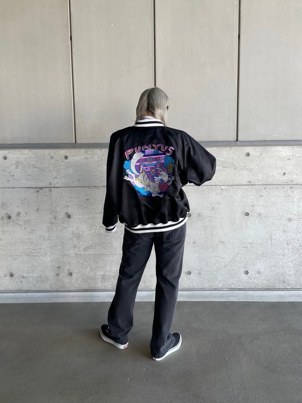 グリーン系のTシャツ/カットソー、ブラック系のブルゾン、ブラック系のデニムパンツを着用したレディースの冬コーディネートの2枚目の写真