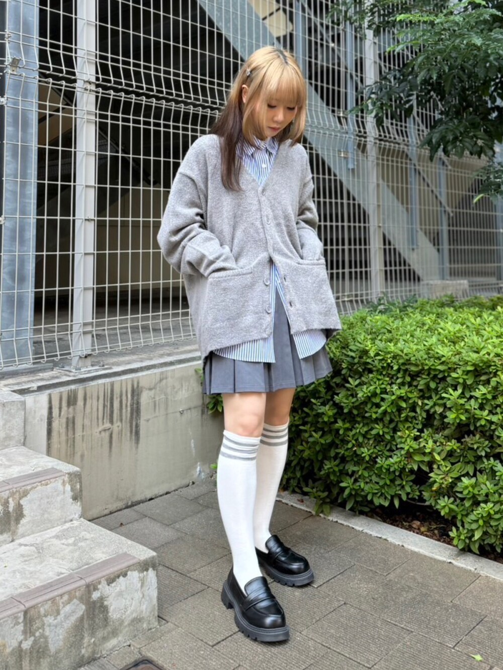 ブルー系のシャツ/ブラウス、グレー系のカーディガン/ボレロ、グレー系のスカートを着用したレディースの秋コーディネートの3枚目の写真