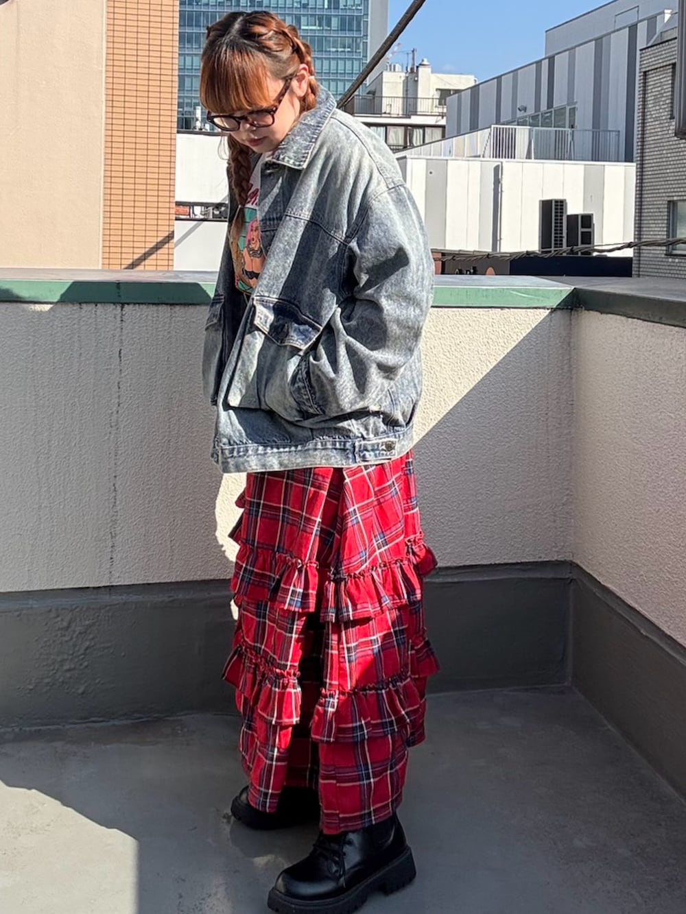 レッド系のスカート、ブルー系のデニムジャケット、ホワイト系のTシャツ/カットソーを着用したレディースの秋コーディネートの5枚目の写真