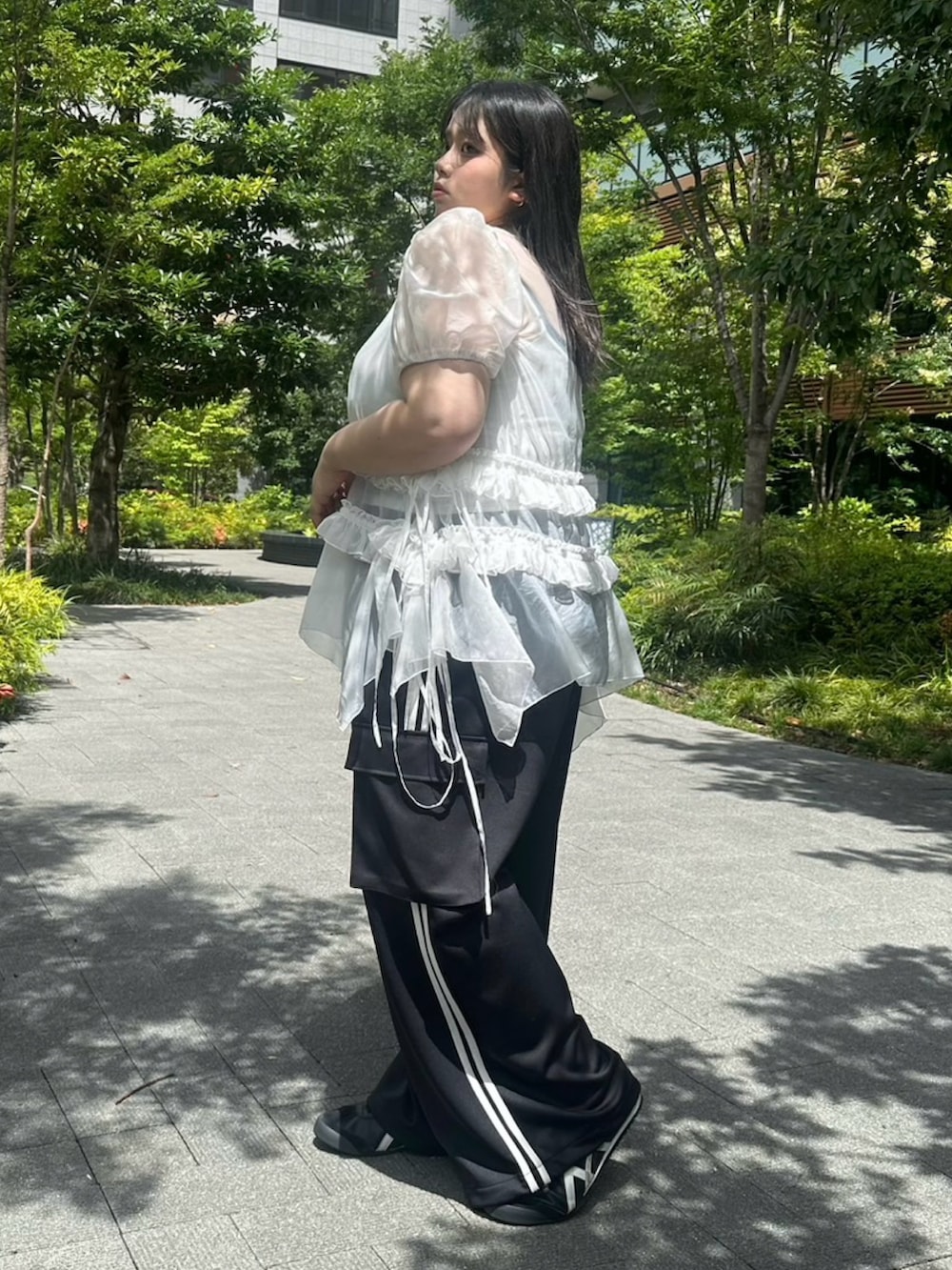 ブラック系のカーゴパンツ、ホワイト系のワンピース、ホワイト系のキャミソールを着用したレディースの夏コーディネートの3枚目の写真