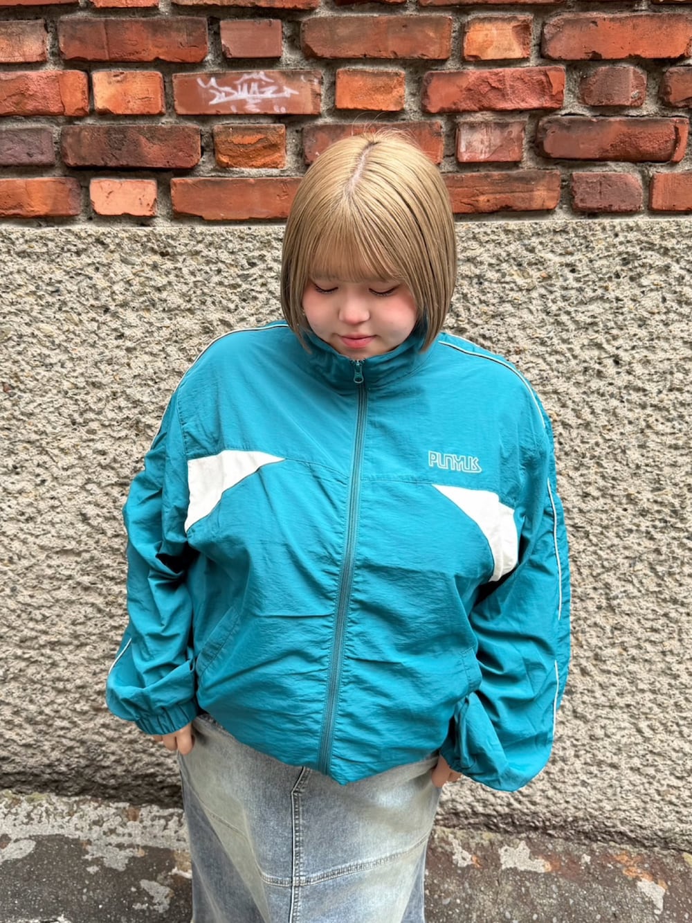 ブルー系のスカート、グリーン系のナイロンジャケットを着用したレディースの秋コーディネートの6枚目の写真