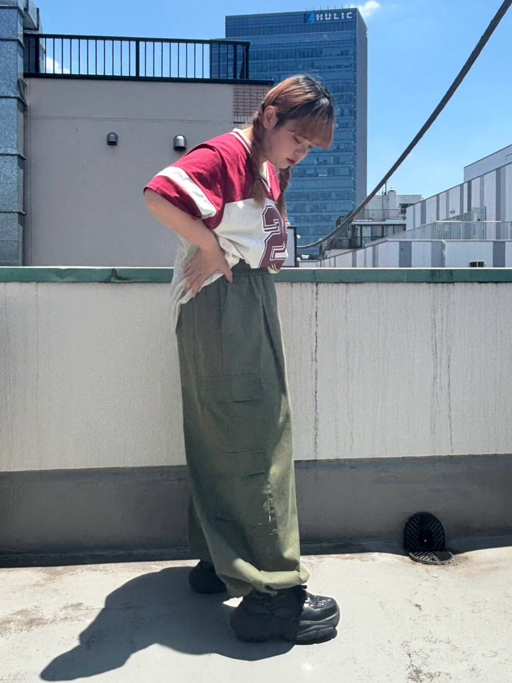グリーン系のカーゴパンツ、レッド系のTシャツ/カットソーを着用したレディースの夏コーディネートの3枚目の写真