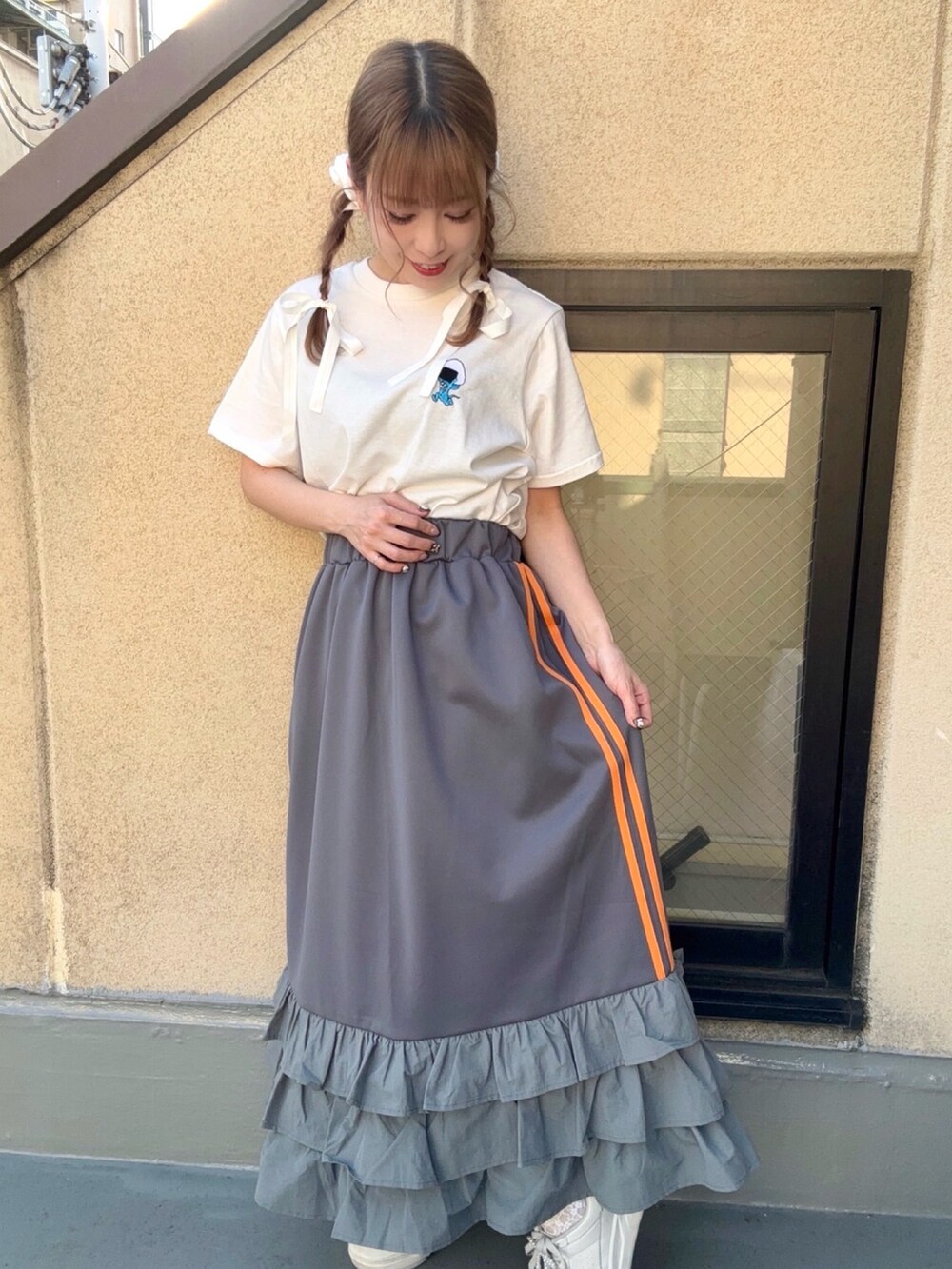 グレー系のスカート、ホワイト系のTシャツ/カットソーを着用したレディースの春コーディネートの3枚目の写真