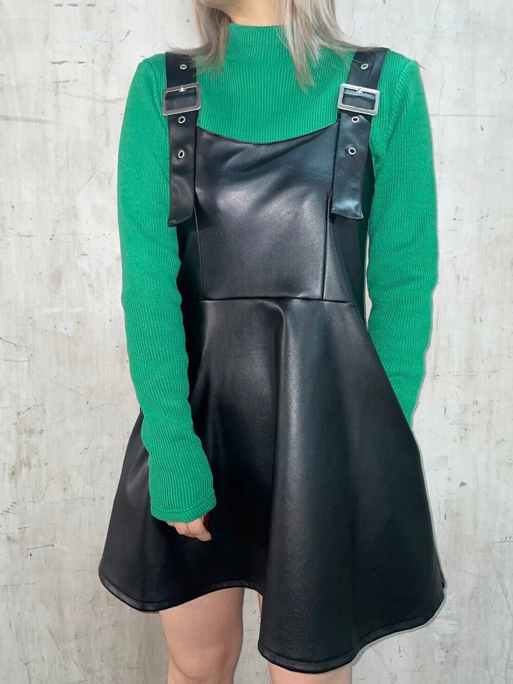 ブラック系のジャンパースカート、グリーン系のニット/セーターを着用したレディースの冬コーディネートの2枚目の写真