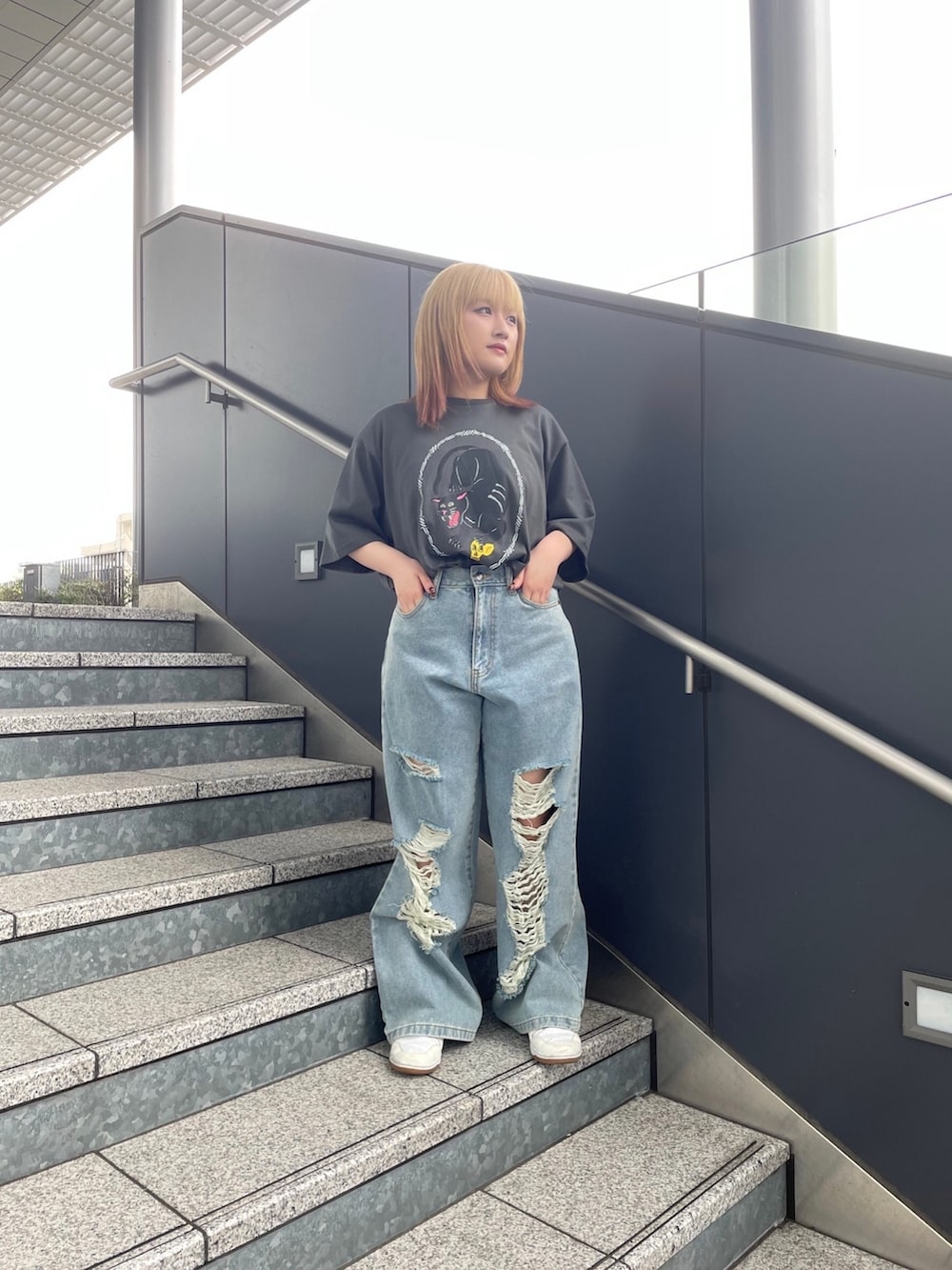 ブラック系のTシャツ/カットソー、ブルー系のデニムパンツを着用したレディースの春コーディネートの2枚目の写真