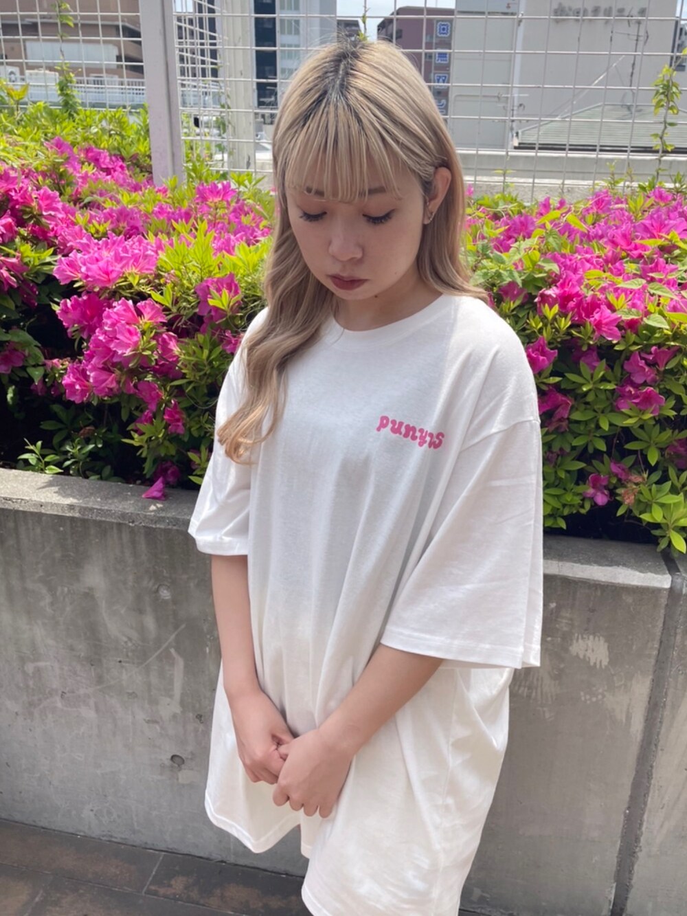 ホワイト系のTシャツ/カットソー、ブラック系のスカートを着用したレディースの春コーディネートの2枚目の写真