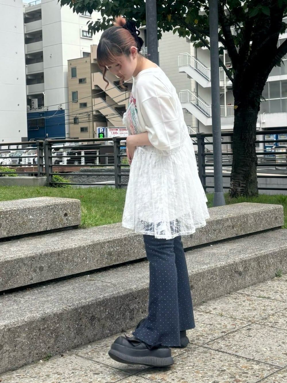 ホワイト系のチュニック、ホワイト系のTシャツ/カットソー、ブルー系のデニムパンツを着用したレディースの夏コーディネートの3枚目の写真