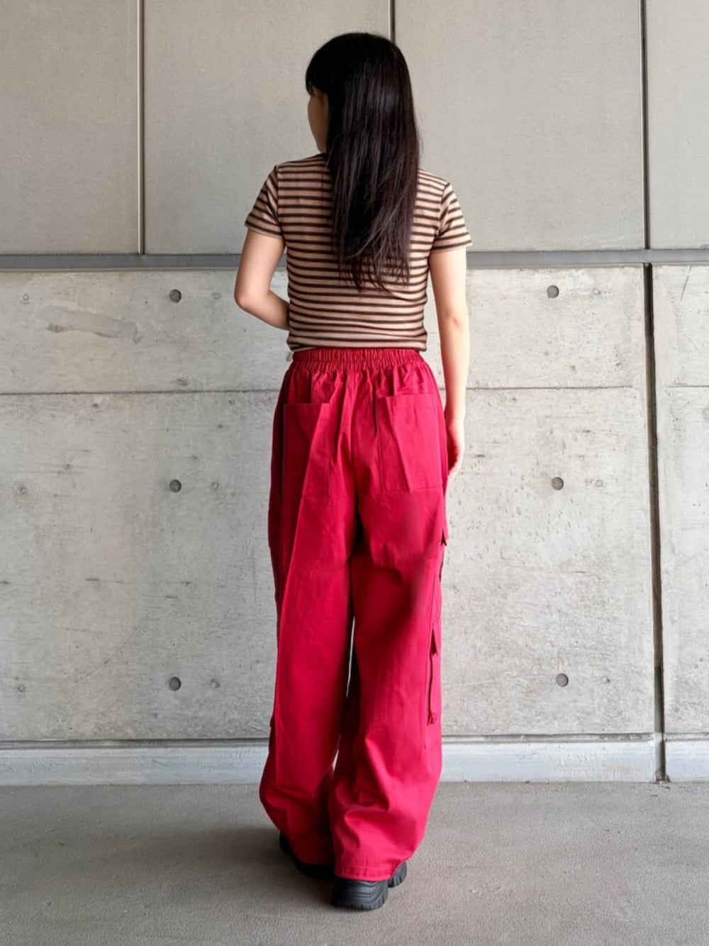 レッド系のカーゴパンツ、ブラウン系のTシャツ/カットソーを着用したレディースの夏コーディネートの6枚目の写真