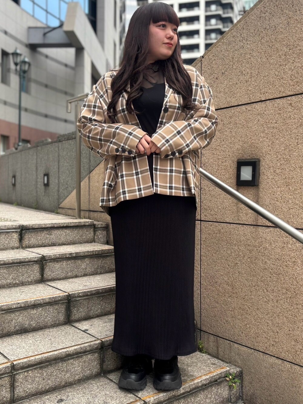 ベージュ系のテーラードジャケット、ブラック系のTシャツ/カットソー、ブラック系のスカートを着用したレディースの春コーディネートの3枚目の写真
