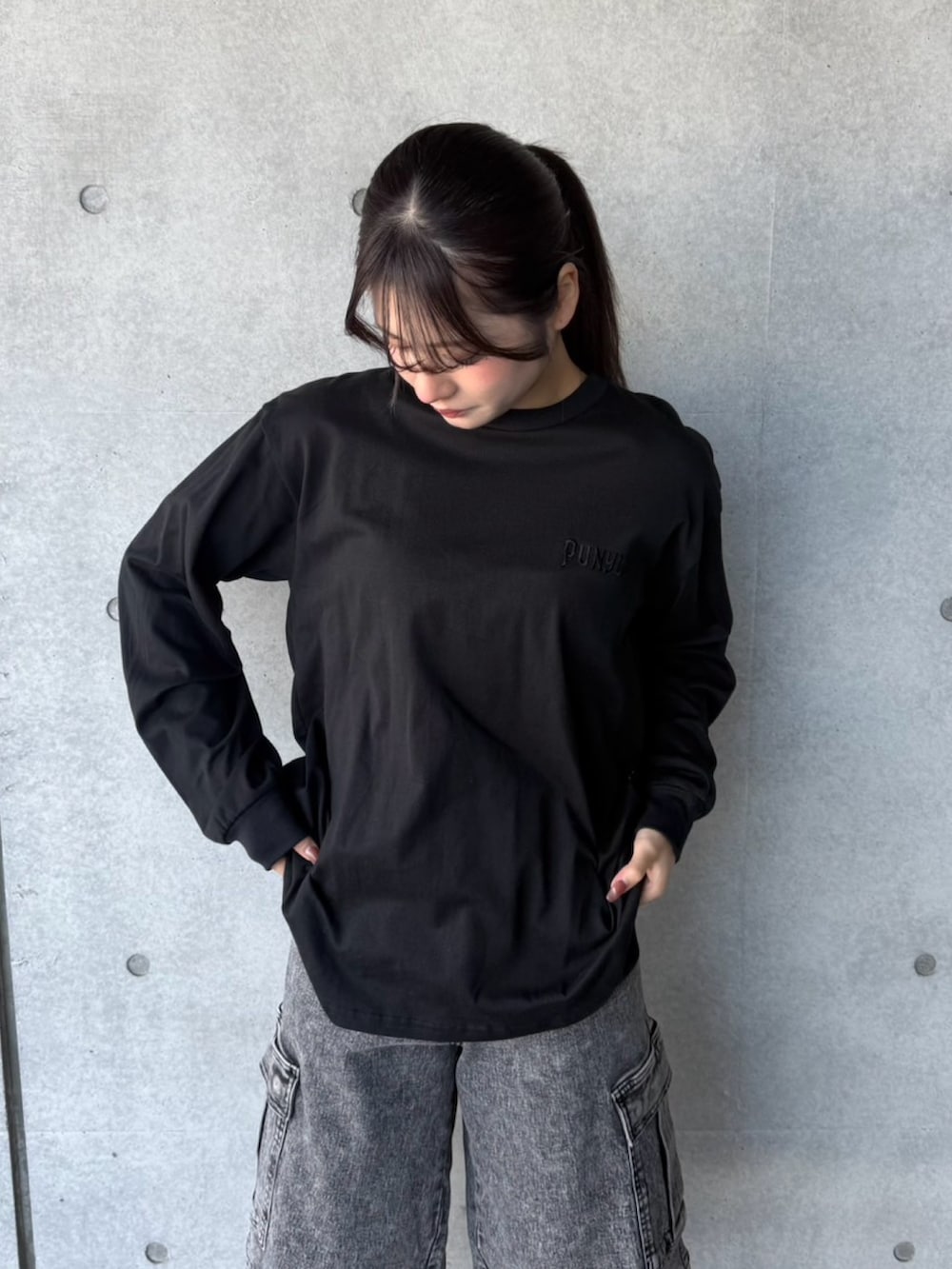 ブラック系のデニムパンツ、ブラック系のTシャツ/カットソーを着用したレディースの冬コーディネートの5枚目の写真