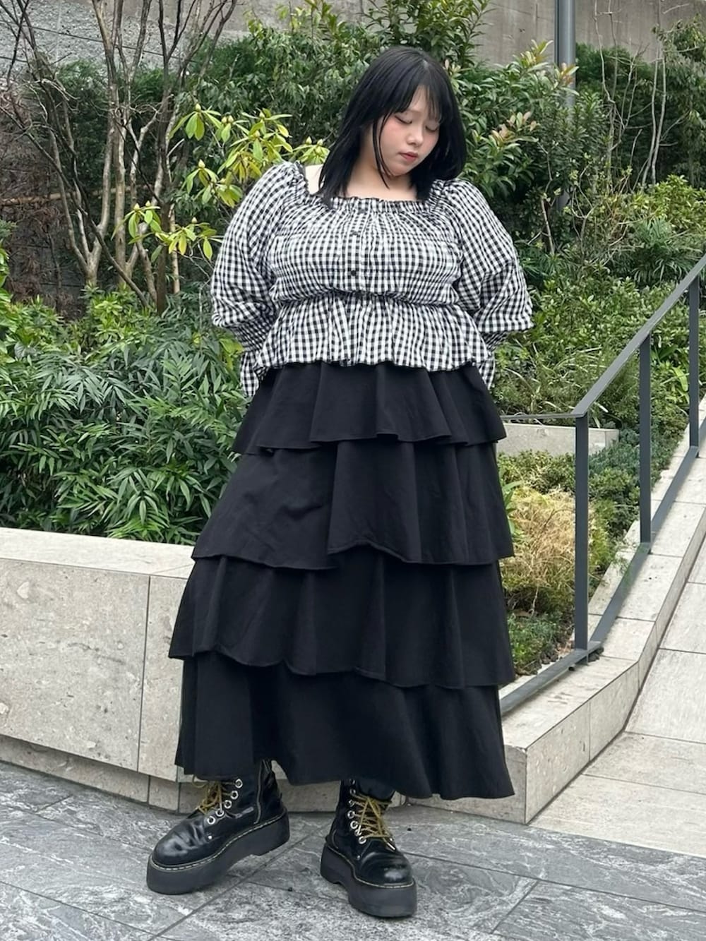 ブラック系のスカート、ブラック系のシャツ/ブラウスを着用したレディースの春コーディネートの2枚目の写真