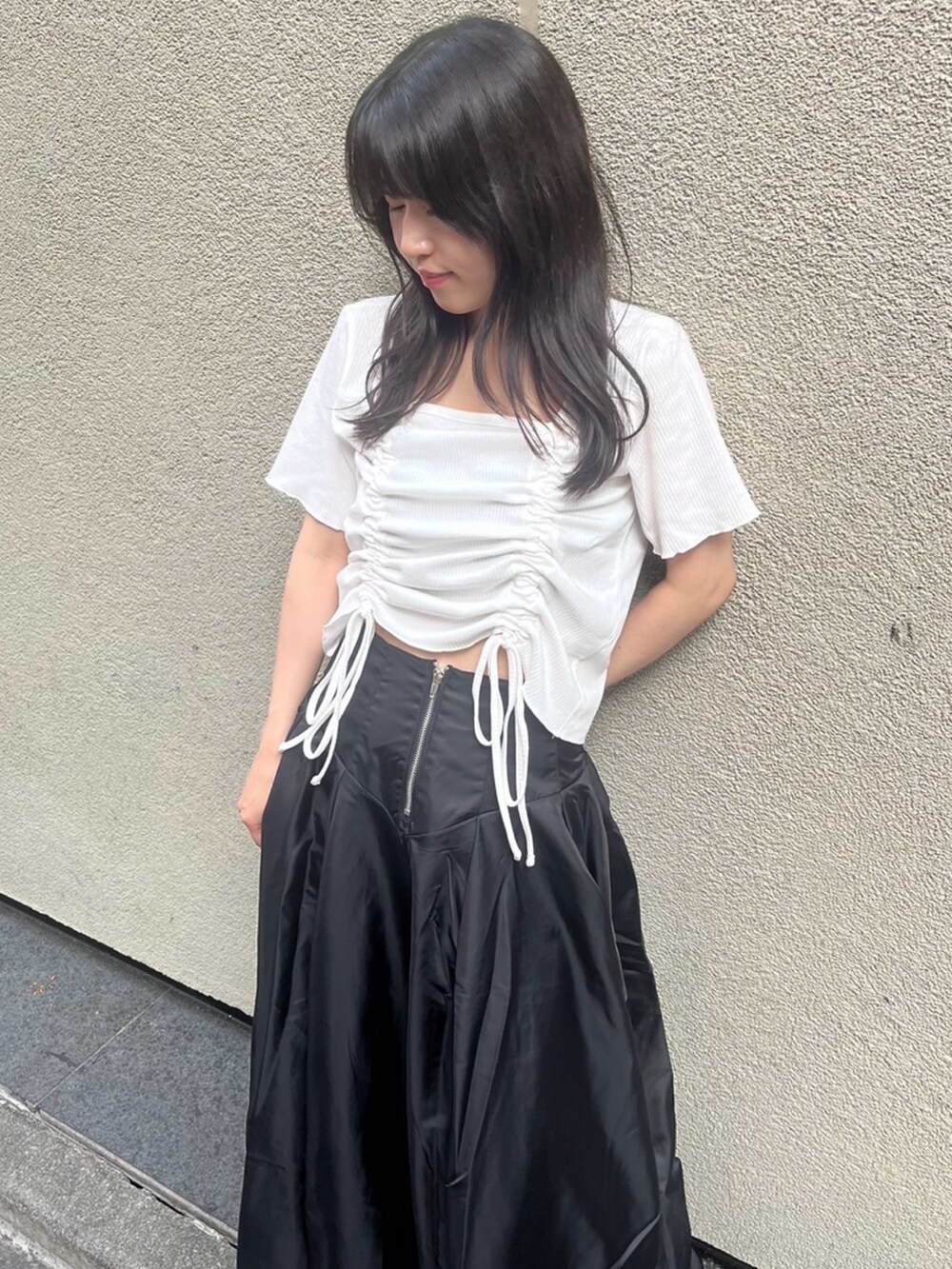 ブラック系のスカート、ホワイト系のTシャツ/カットソーを着用したレディースの夏コーディネートの4枚目の写真