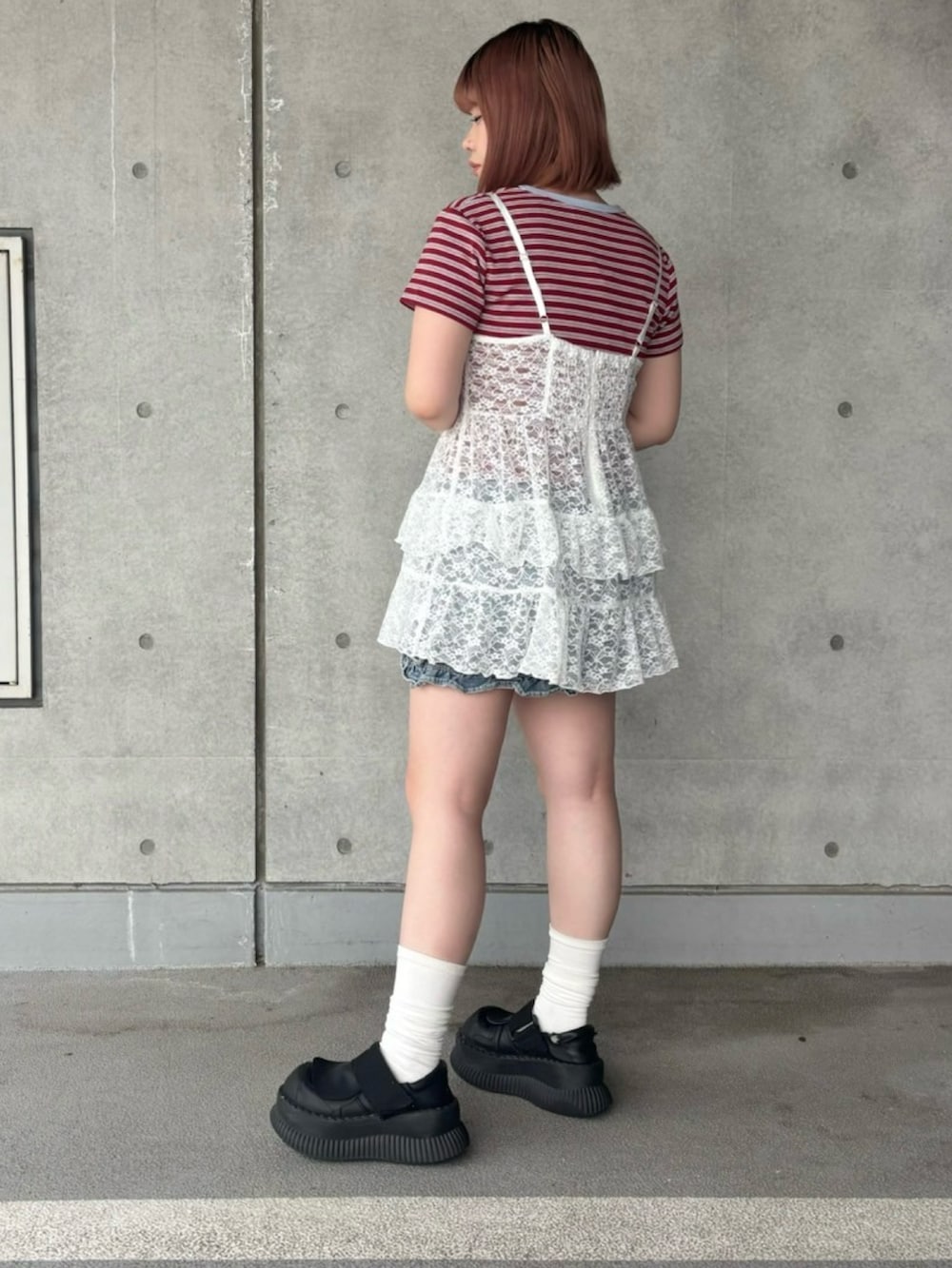 ブルー系のデニムスカート、レッド系のTシャツ/カットソー、ホワイト系のワンピースを着用したレディースの春コーディネートの4枚目の写真