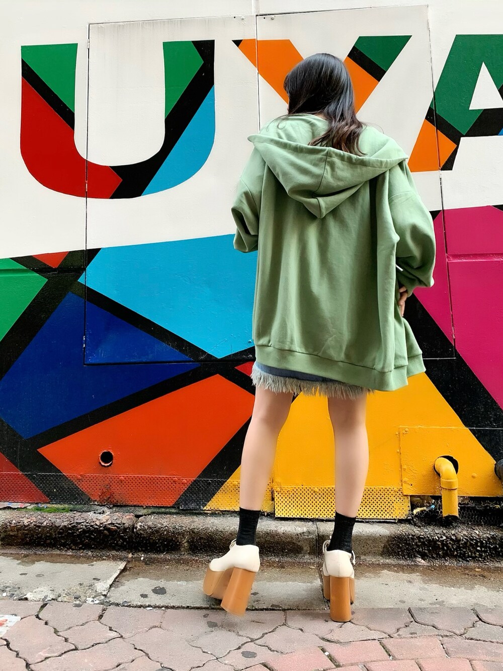 ベージュ系のTシャツ/カットソー、グリーン系のパーカー、ブルー系のデニムスカートを着用したレディースの春コーディネートの2枚目の写真