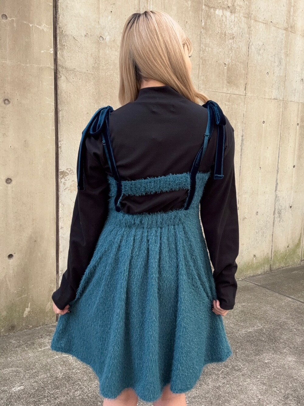 ブルー系のワンピース、ブラック系のニット/セーターを着用したレディースの冬コーディネートの3枚目の写真